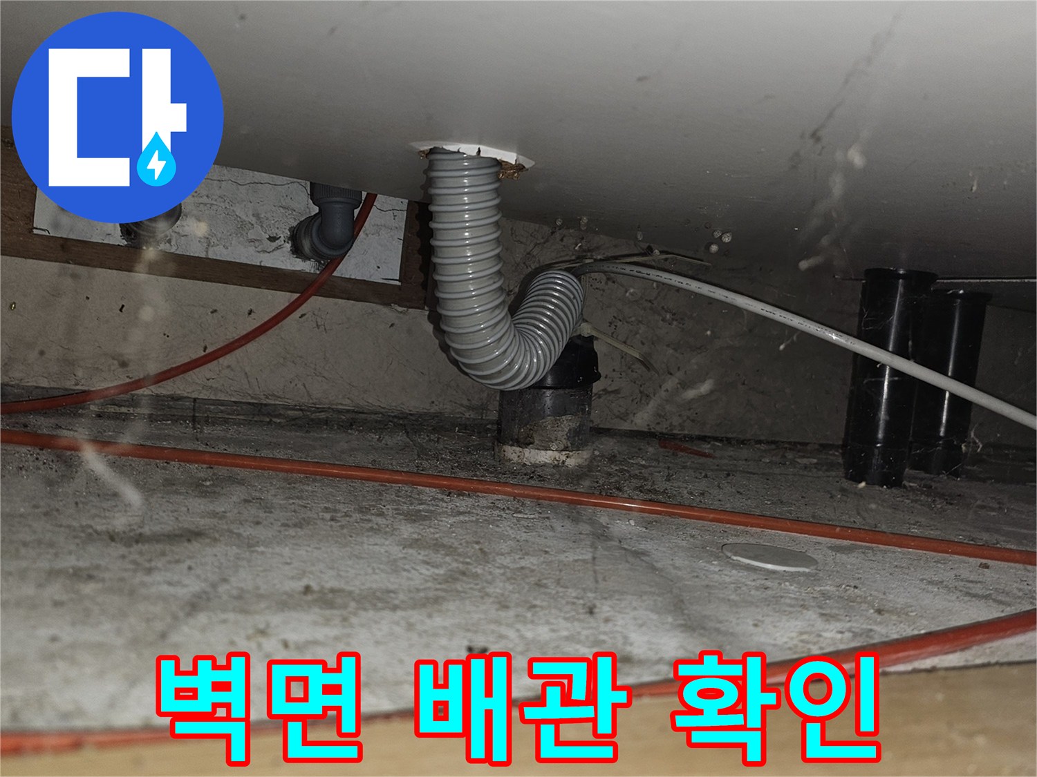 벽체 사이로 연결된 주름관과 수도 배관 모습