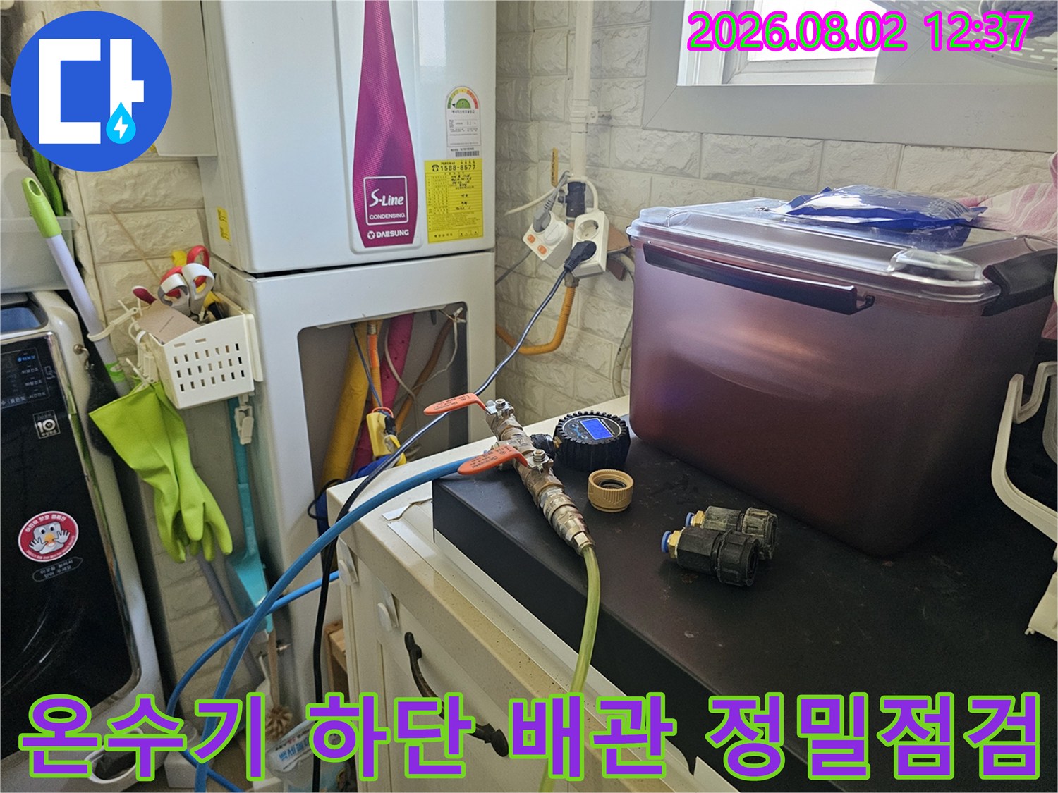 노출된 온수기 하부 배관에 탐지 장비를 연결하여 누수 유무를 확인하는 모습