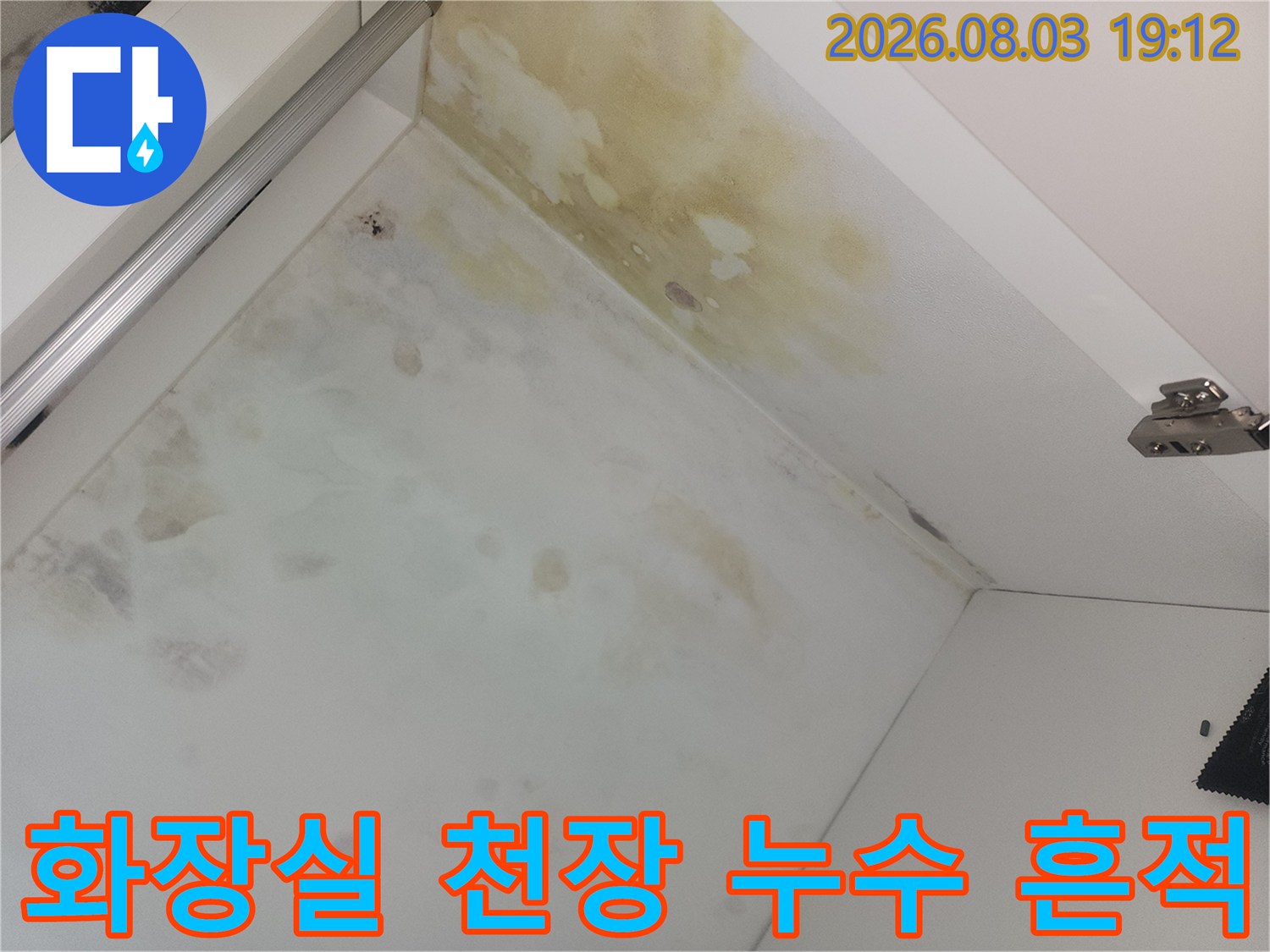 화장실 천장 마감재에 발생한 노란색 누수 얼룩과 배관 트랩 부근의 오염 상태