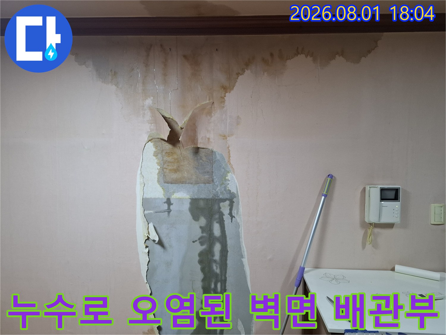 노출된 파손 배관과 주변 습기 흔적이 선명한 벽면 모습