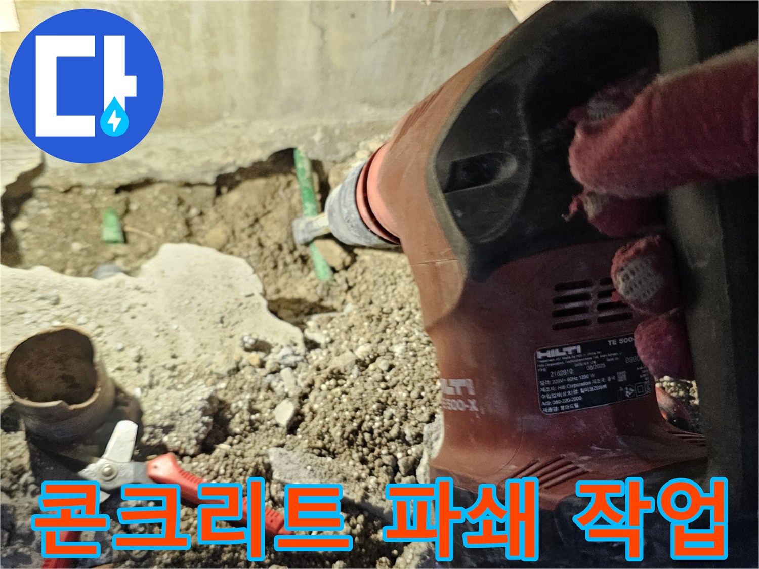 전동 장비를 사용하여 콘크리트를 부수는 현장 사진입니다.