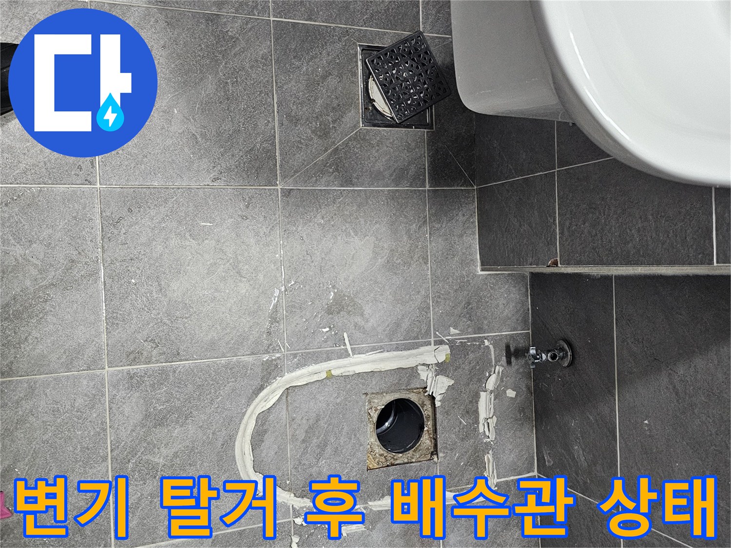 변기 아래쪽 오수관 주변의 이물질과 파손된 타일 마감