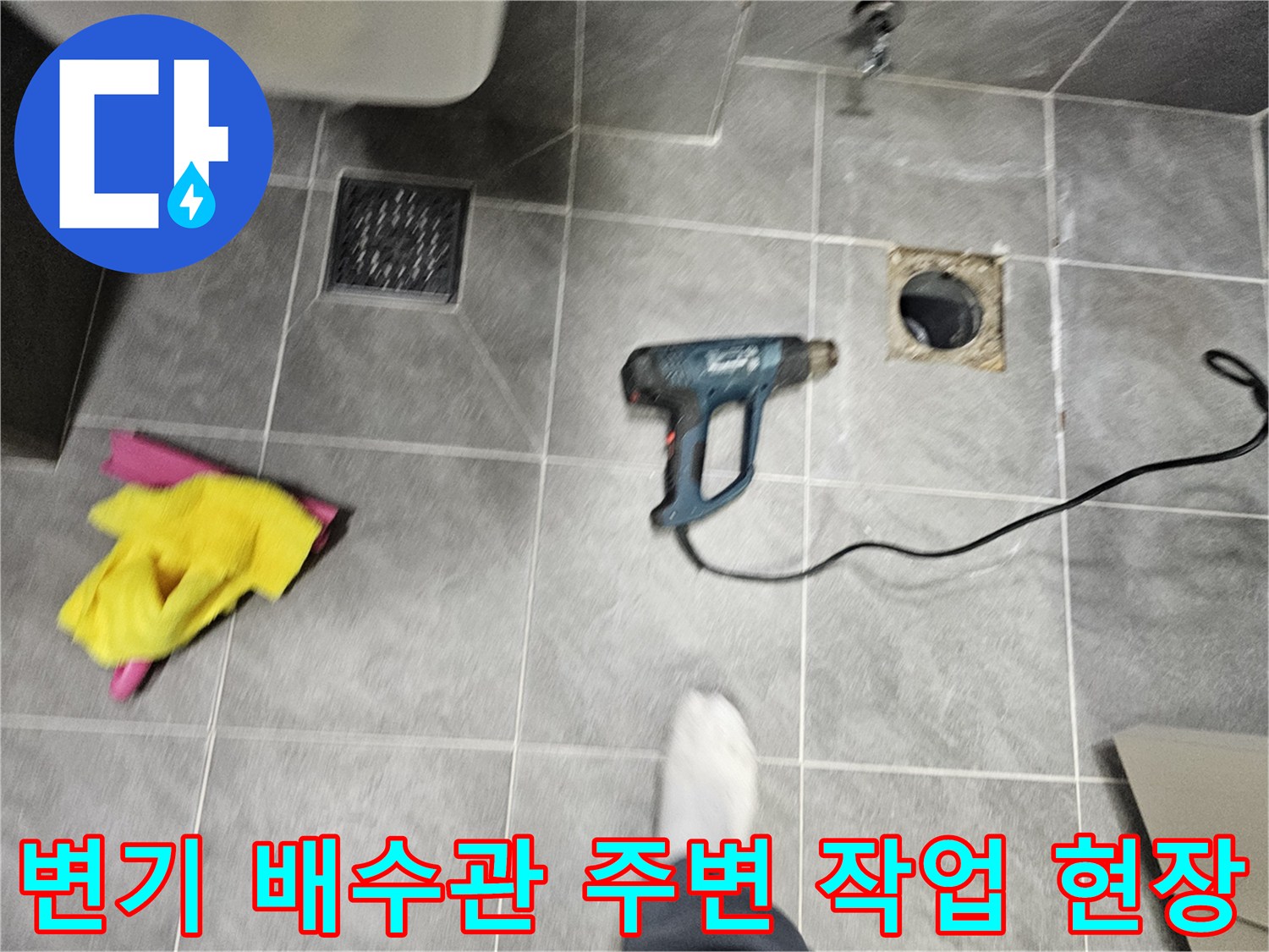작업 도구가 놓인 화장실 바닥의 오수관 모습
