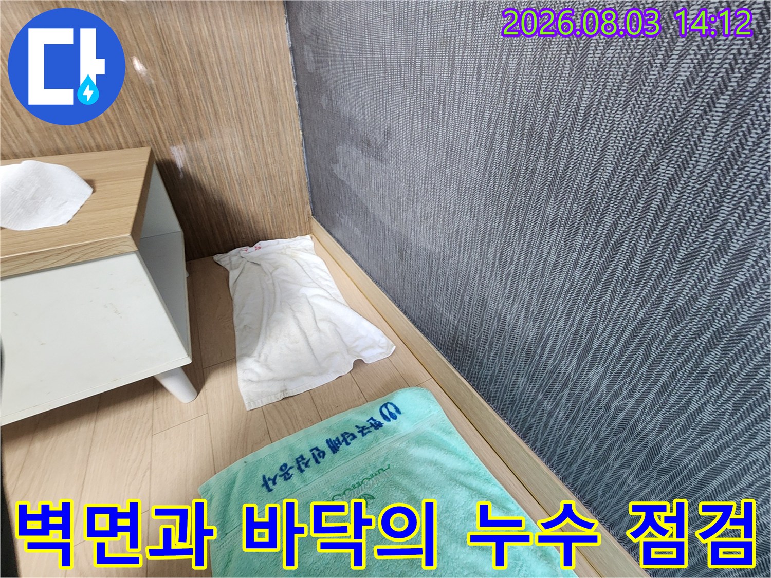 회색 벽면과 나무 질감 마감재가 있는 공간에서의 누수 정밀 진단 현장