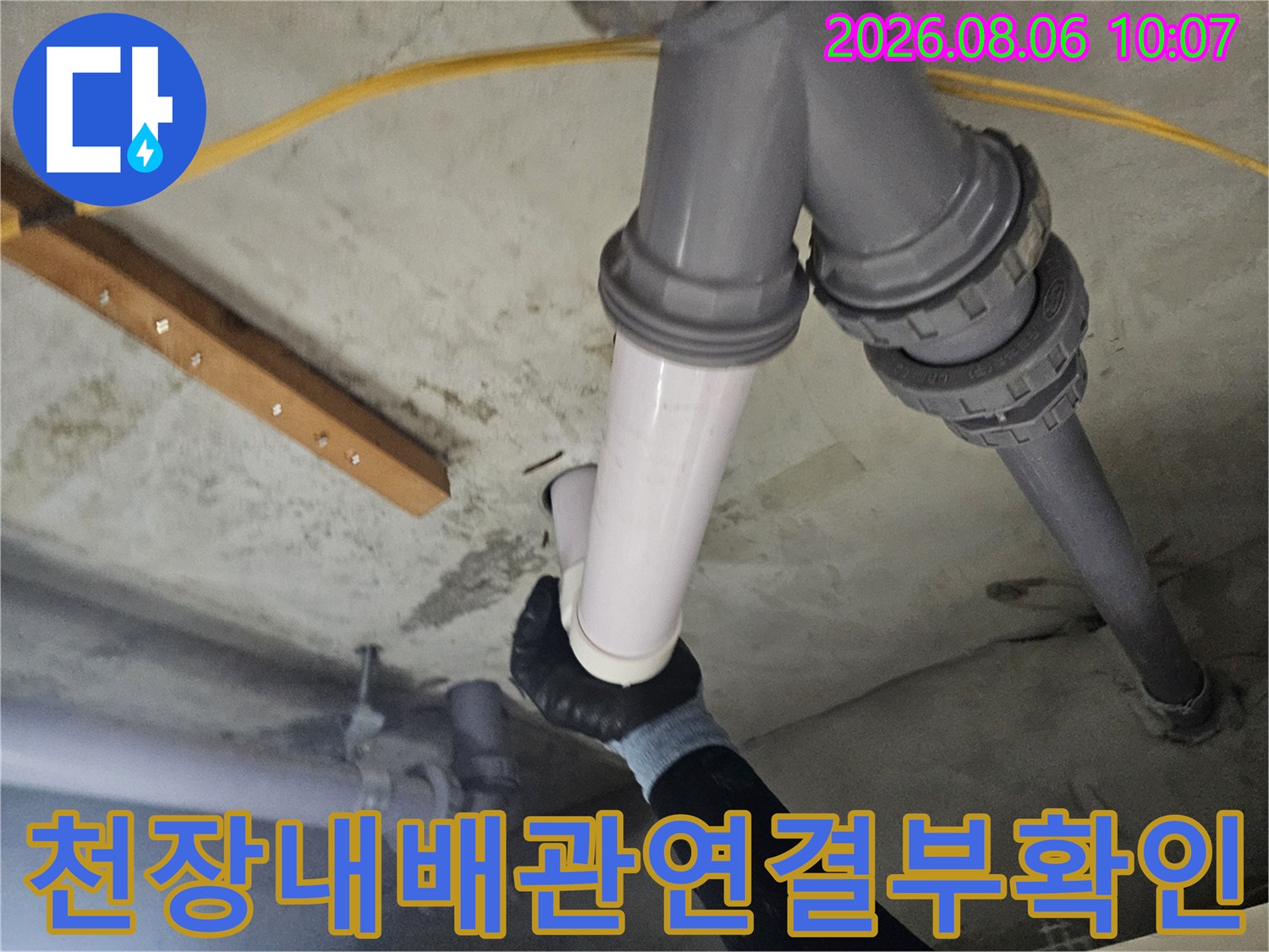 화장실 천장 점검구를 통해 배관 연결 부위를 세밀하게 조사하는 모습