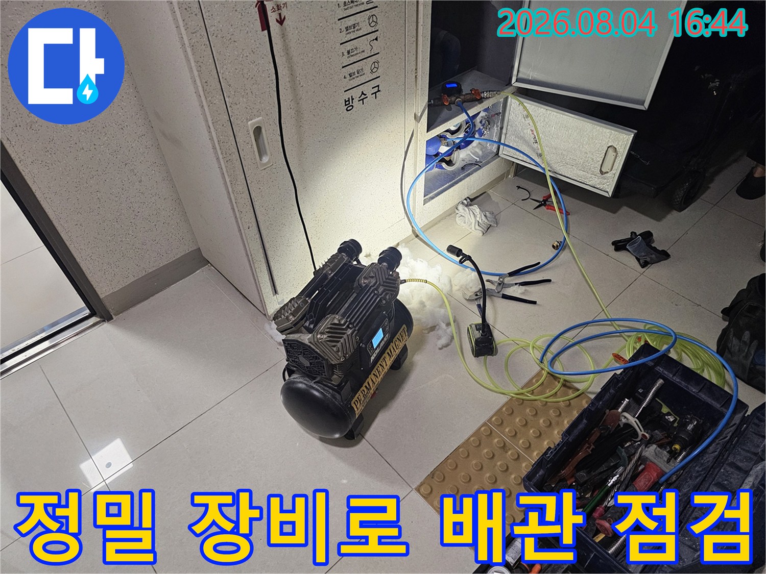 첨단 내시경과 세척 장비를 배치하여 화장실 천장 배관 상태를 면밀히 검사하는 장면