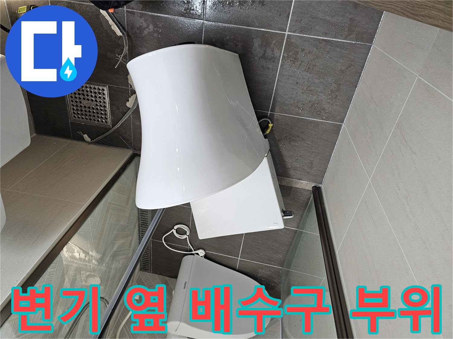 화장실 변기와 하수구 배수구가 위치한 바닥 타일 사진입니다.