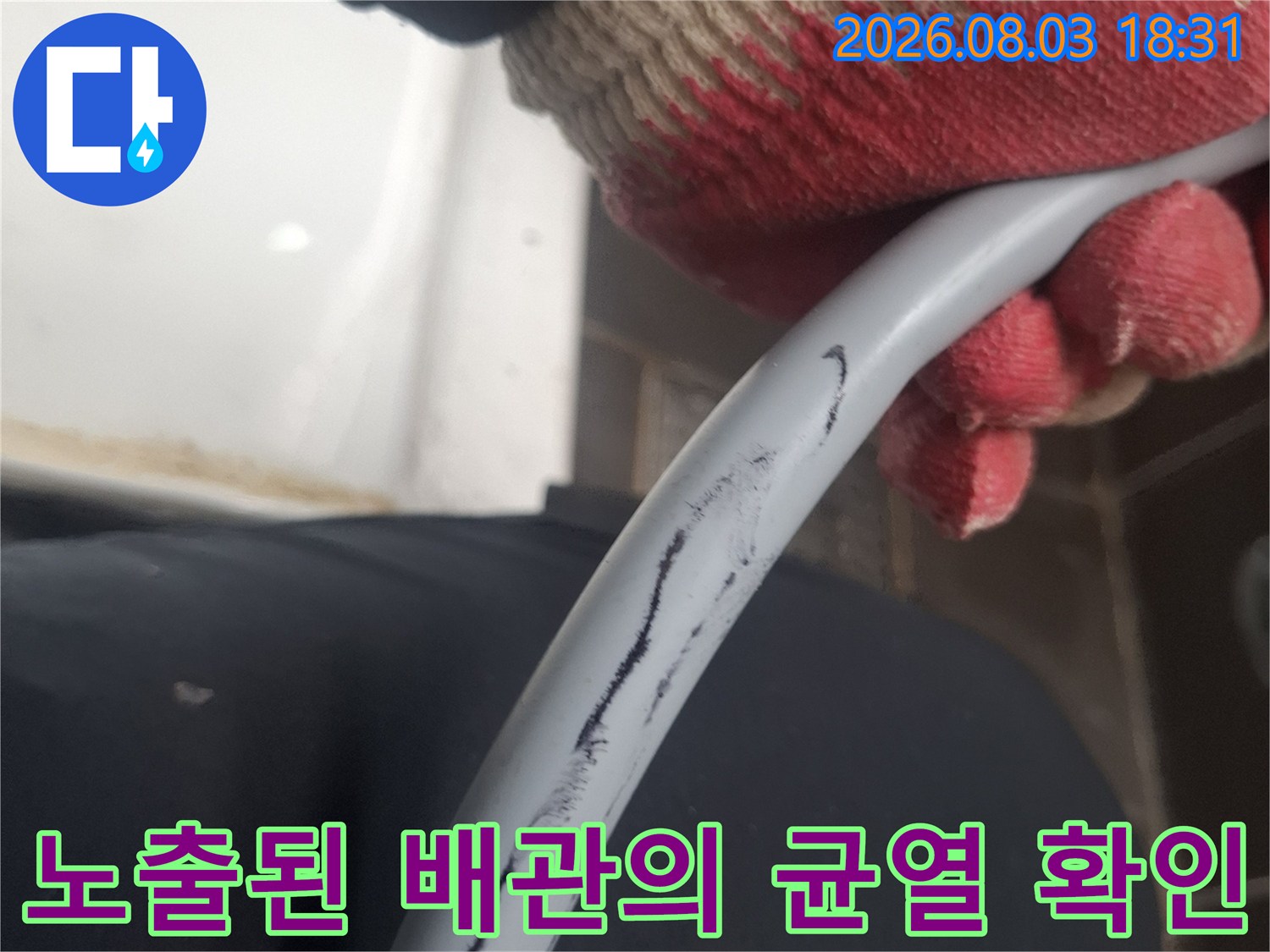 작업자가 장갑을 끼고 누수가 발생한 직수 배관 구간을 들어 올려 점검하는 장면