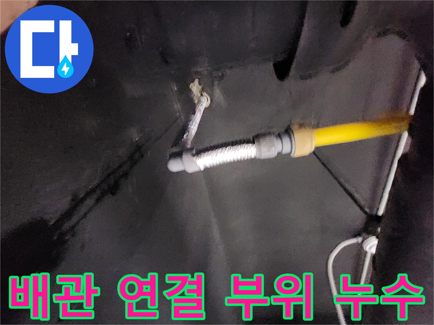 물기가 스며든 벽면과 노란색 배관의 연결 상태를 보여주는 사진