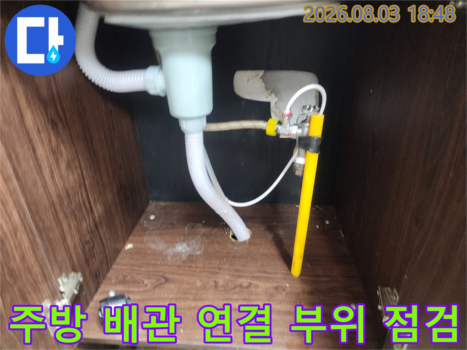 싱크대 하부의 노란색 관과 흰색 유연호스 결합부 촬영