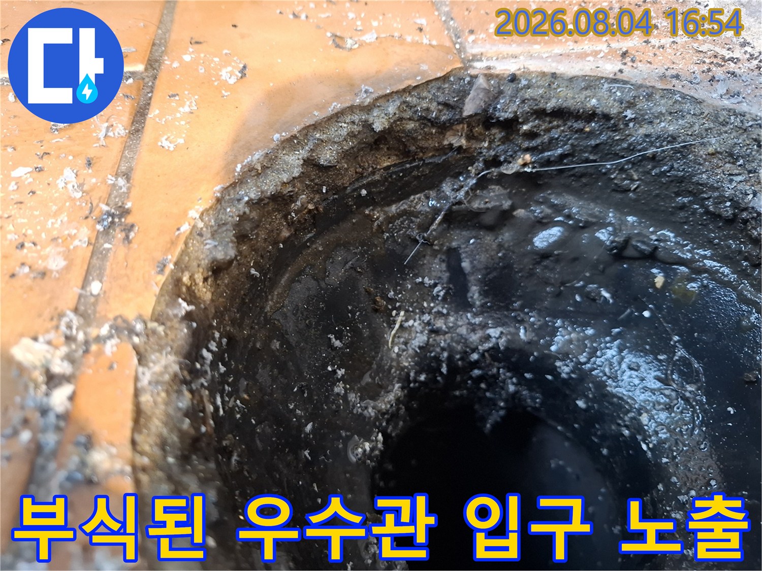 우수관 주변의 파손된 시멘트와 훼손된 방수층을 근접 촬영한 모습