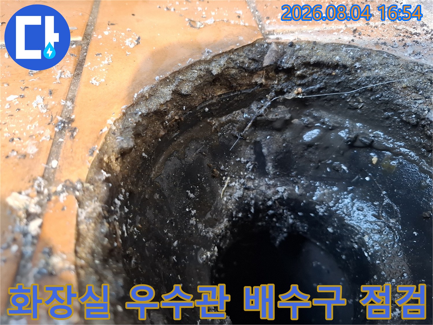 화장실 바닥 타일과 연결된 우수관 주변의 노후된 배수부위 점검 사진