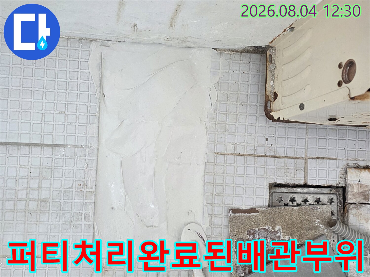 백색 충진재를 사용하여 배관 주변을 매끄럽게 마감한 시공 현장