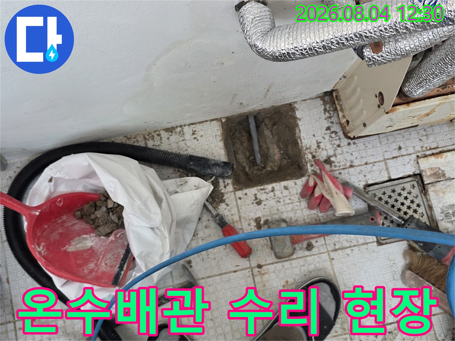 은박 마감재로 감싸진 온수 배관과 누수 탐지 장비가 있는 공사 현장