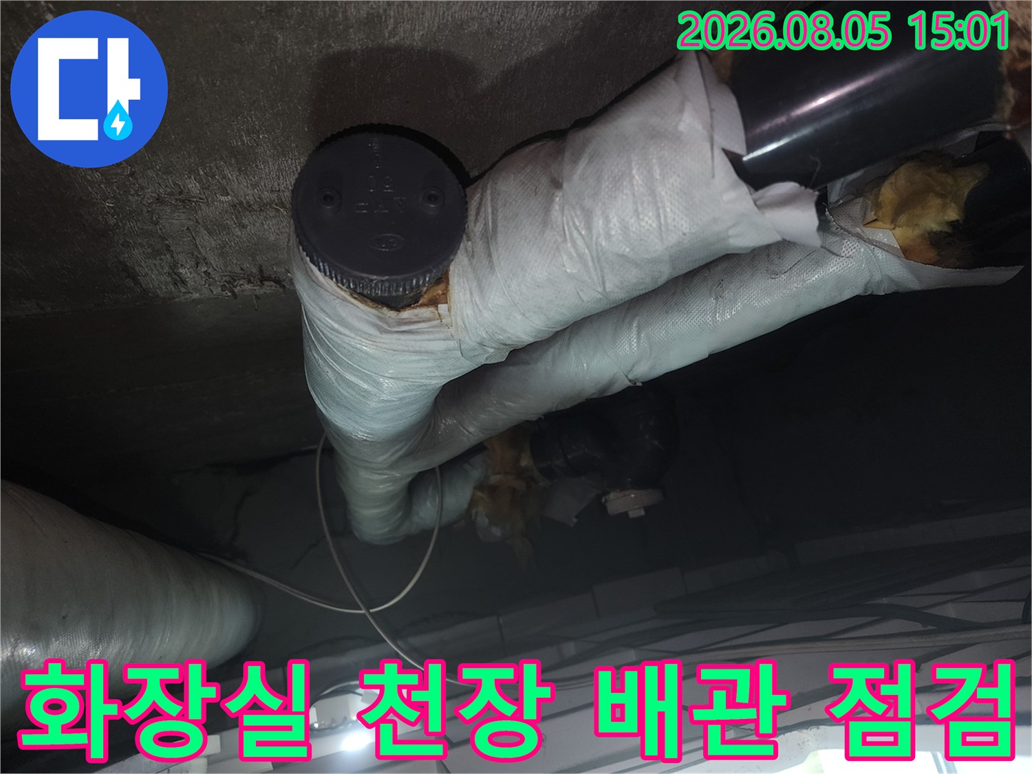 보온재로 감싸진 화장실 천장 배관과 밸브를 점검하는 모습