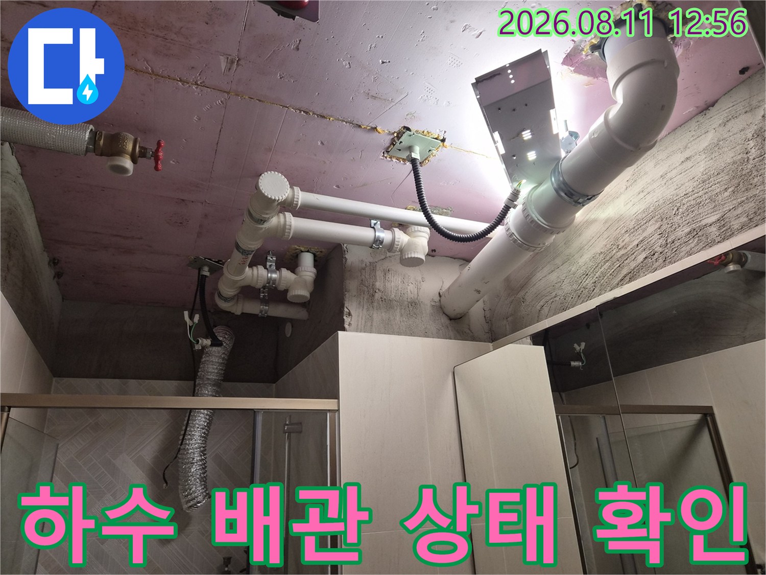 천장에 설치된 하얀색 PVC 배관과 슬라브의 누수 흔적을 촬영한 사진입니다.