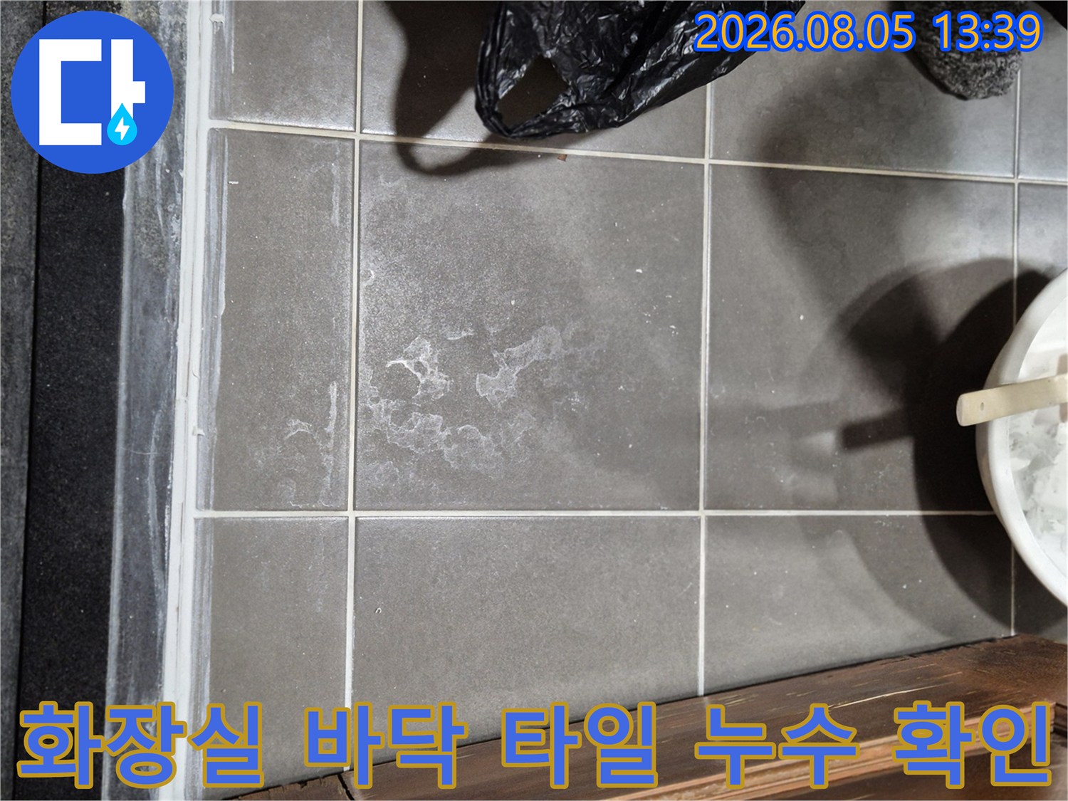 타일 표면의 수분 흔적과 배수구 주변 상태를 정밀 점검함