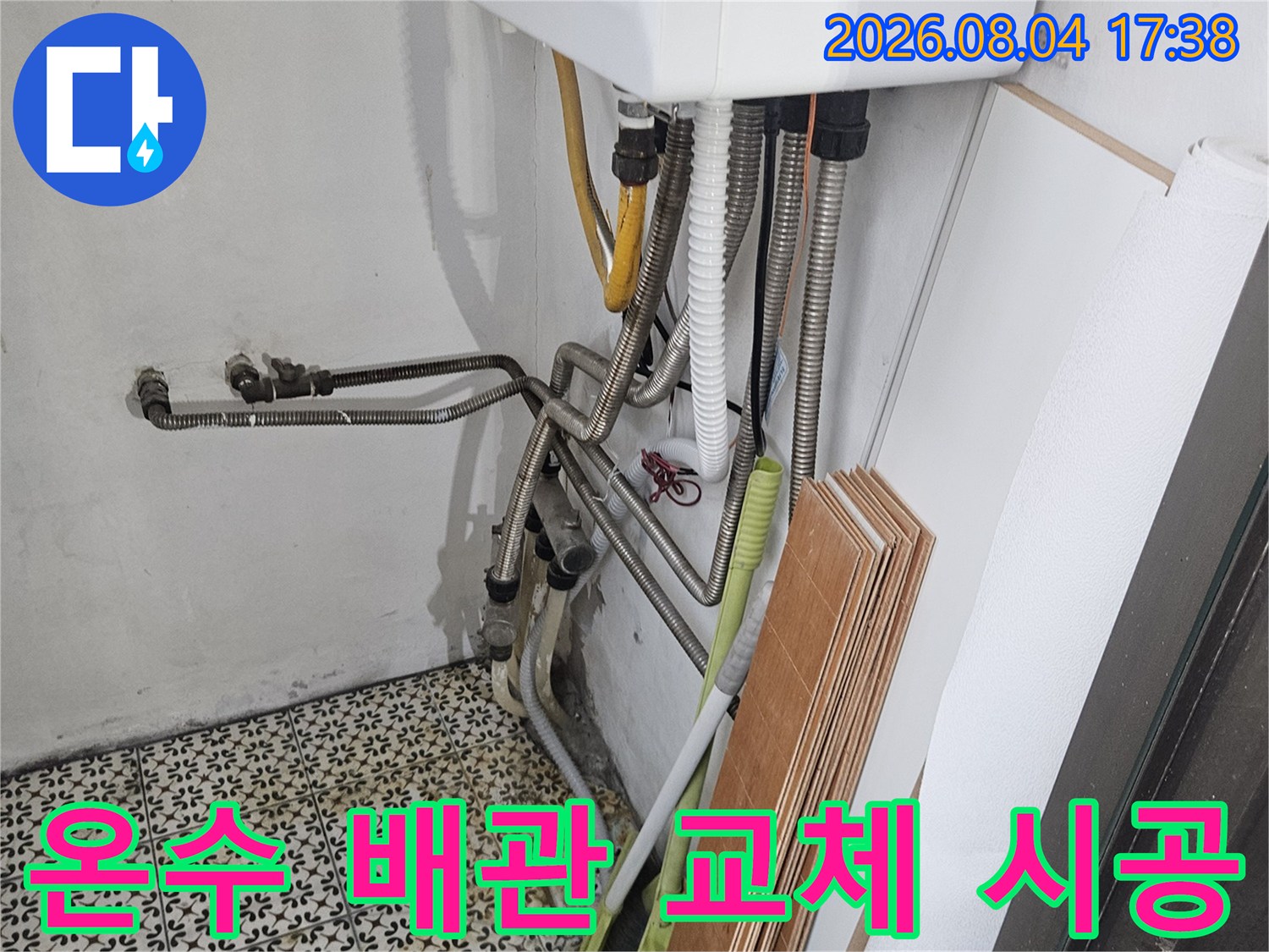 노란색 보온재가 씌워진 온수배관과 금속 관의 결합부 공사 장면