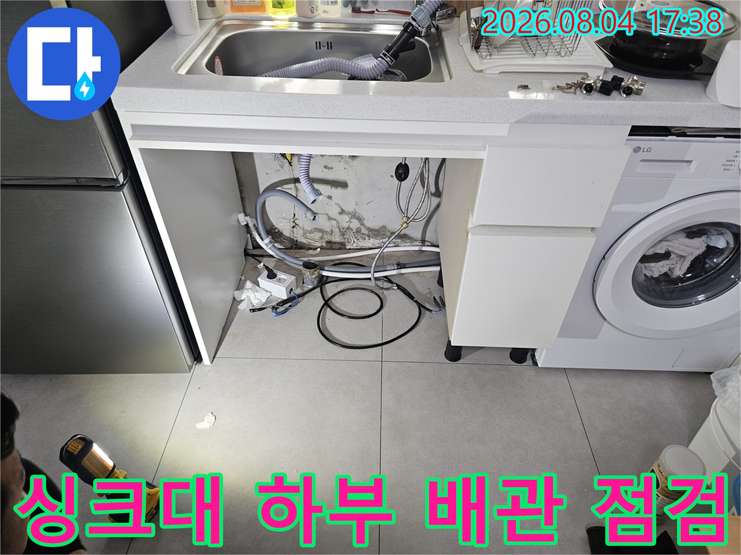 싱크대 아래쪽 노출된 수도 배관과 연결 부위 상세 점검 모습