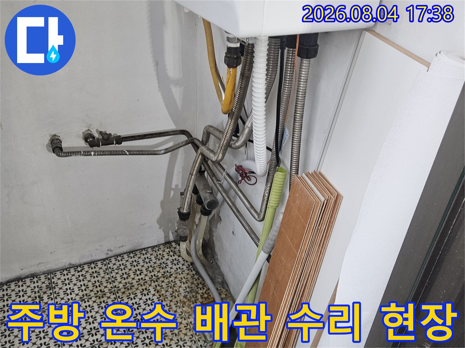 주방 싱크대 하단부 노란색 보온재가 감싸진 온수 배관 교체 작업 모습