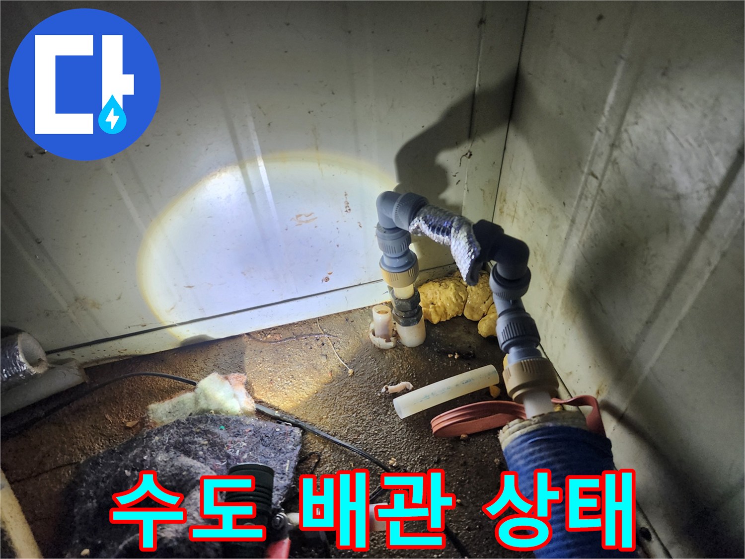 보온재가 씌워진 배관의 연결 부위와 주변 바닥의 습기 상태 - 누수 진단 중