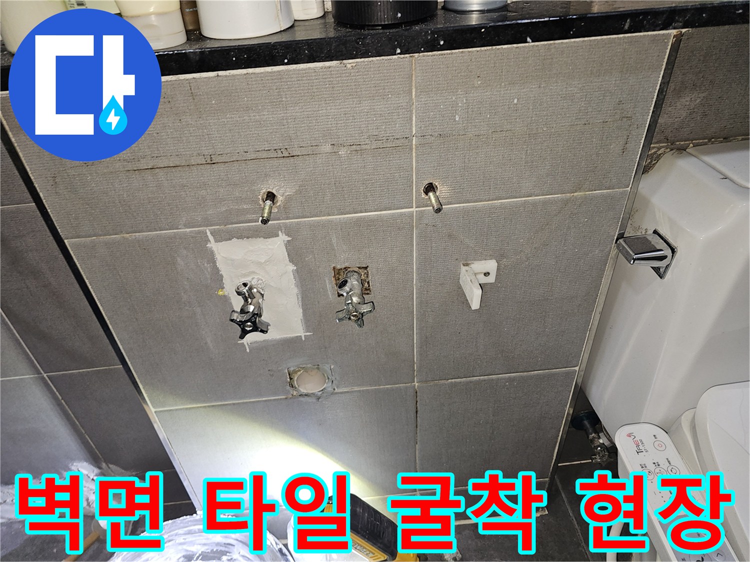 욕실 벽의 타일을 제거하여 내부 배관을 노출시킨 공사 중인 모습