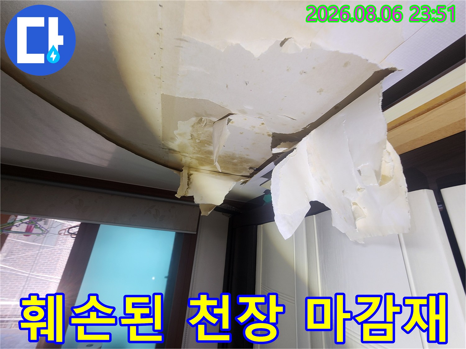 심하게 변색되고 찢어진 거실 천장 도배지 모습입니다.
