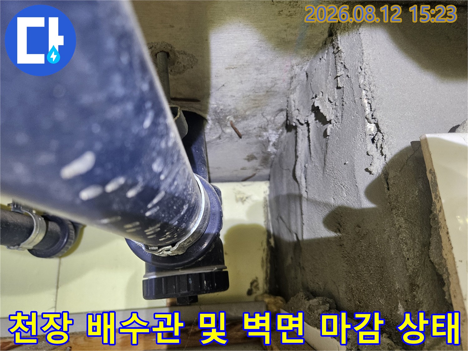 거칠게-마감된-콘크리트-벽면과-설치된-파란색-플라스틱-배관