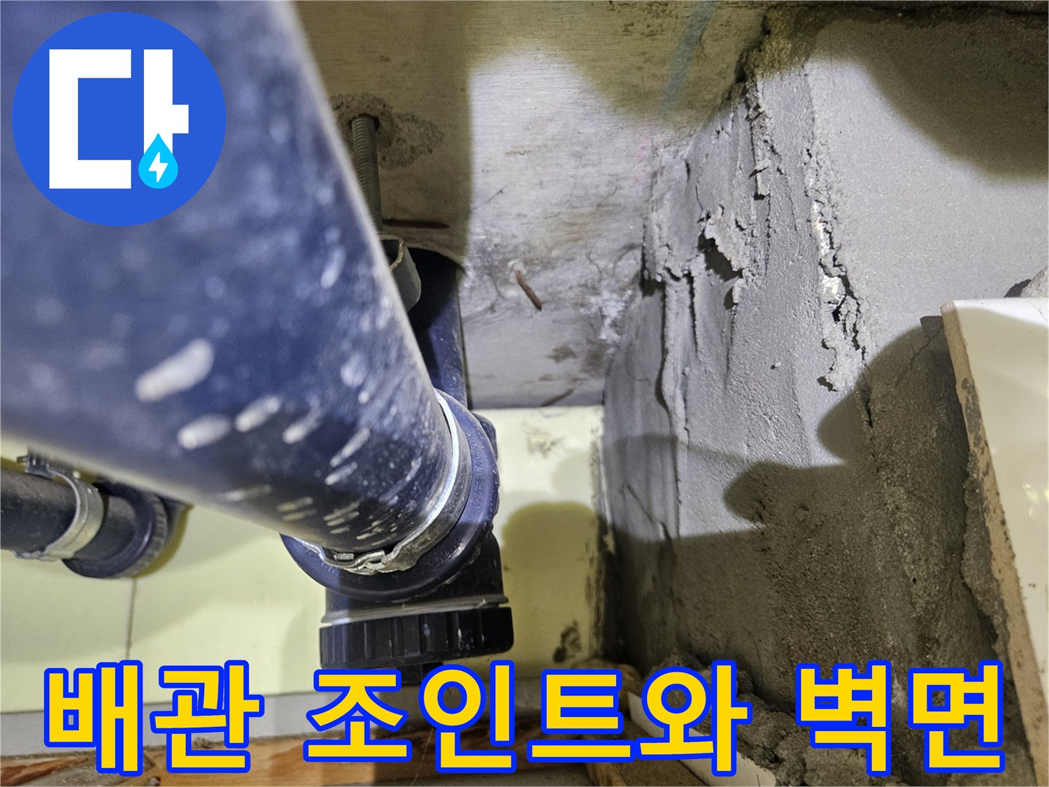 하수구 배관의 연결 소켓과 거친 콘크리트 벽면이 맞닿은 모습