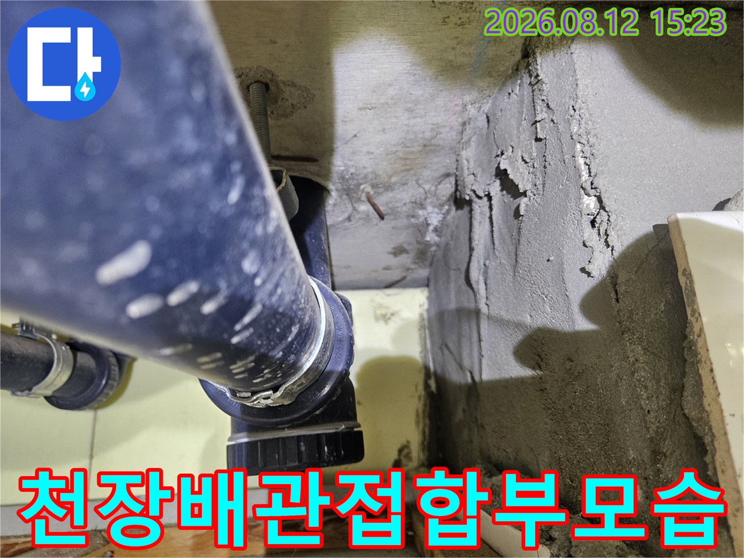 화장실 천장의-파란색 플라스틱 배관과 불규칙한 시멘트 마감재의 모습