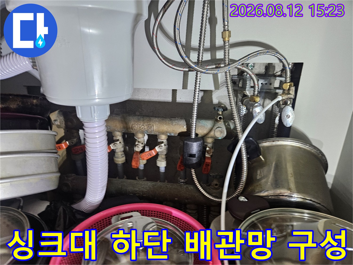 흰색 플라스틱 정수기 장치와 스테인리스 소재의 유연한 급수 배관들이 연결된 모습