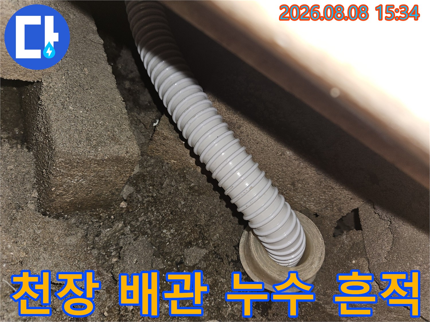 습기로 인해 어둡게 변한 콘크리트와 하얀색 주름 배관