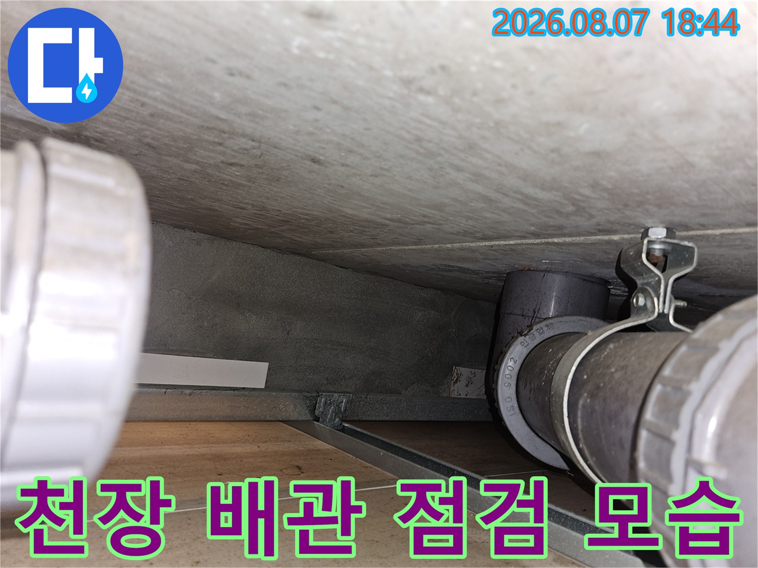 아파트 천장 내부의 배관 연결 부위와 하수관 상태를 확인하는 장면
