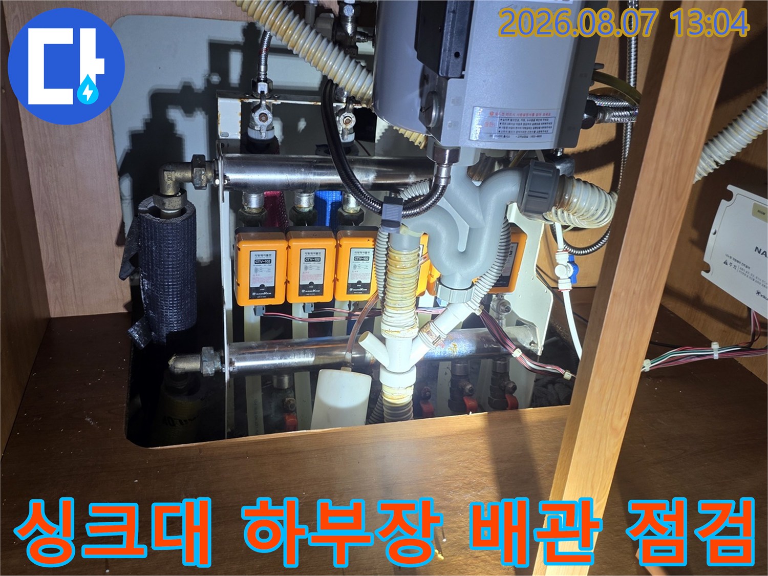 성북구 장위동 싱크대 하부장 내부의 앵글밸브와 수도 배관 상태 점검 사진입니다.