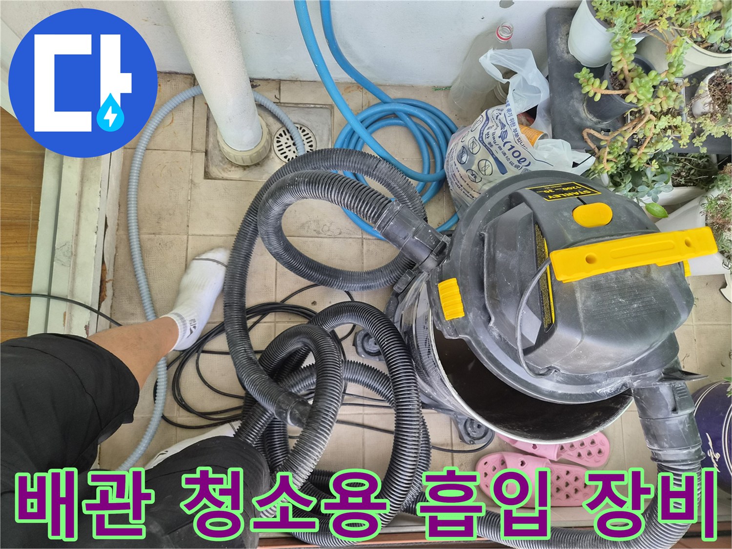 바닥 타일 위 작업 중인 산업용 진공청소기와 배관 호스들