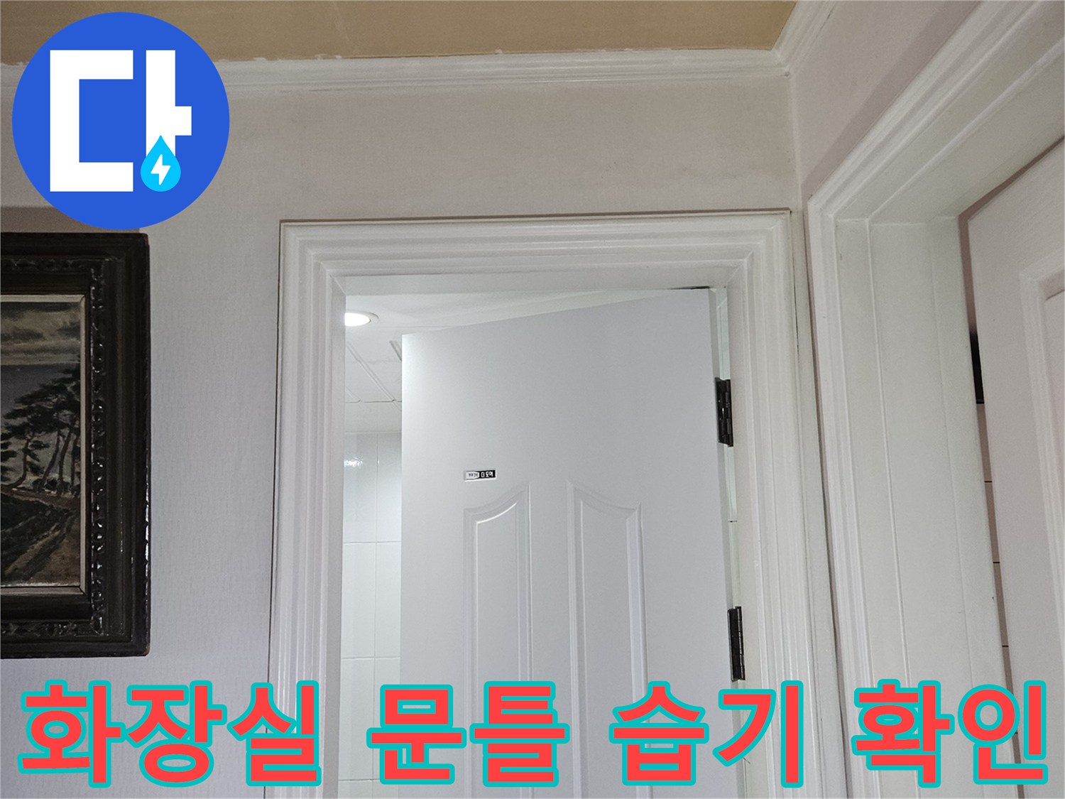 화장실 문 주변의 도어 프레임과 벽면 접합부 상태를 보여주는 사진입니다.