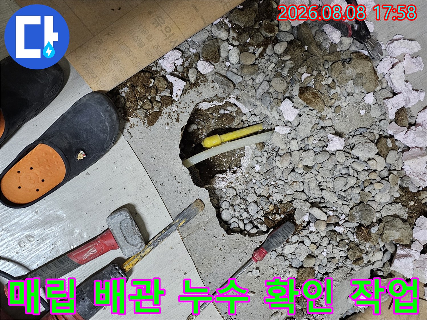 바닥재를 들어내고 콘크리트를 깨서 내부 배관을 드러낸 공사 현장 모습입니다.