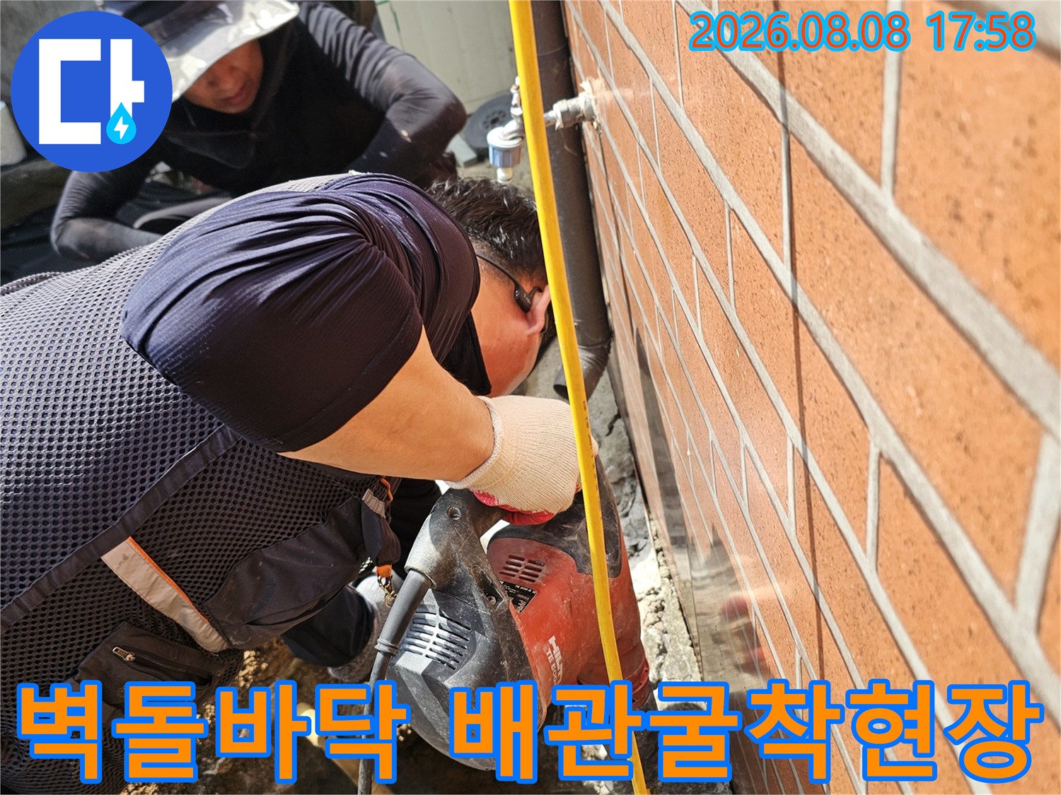 붉은 벽돌 아래 콘크리트 층을 파헤쳐 누수 지점을 찾는 작업 현장입니다.