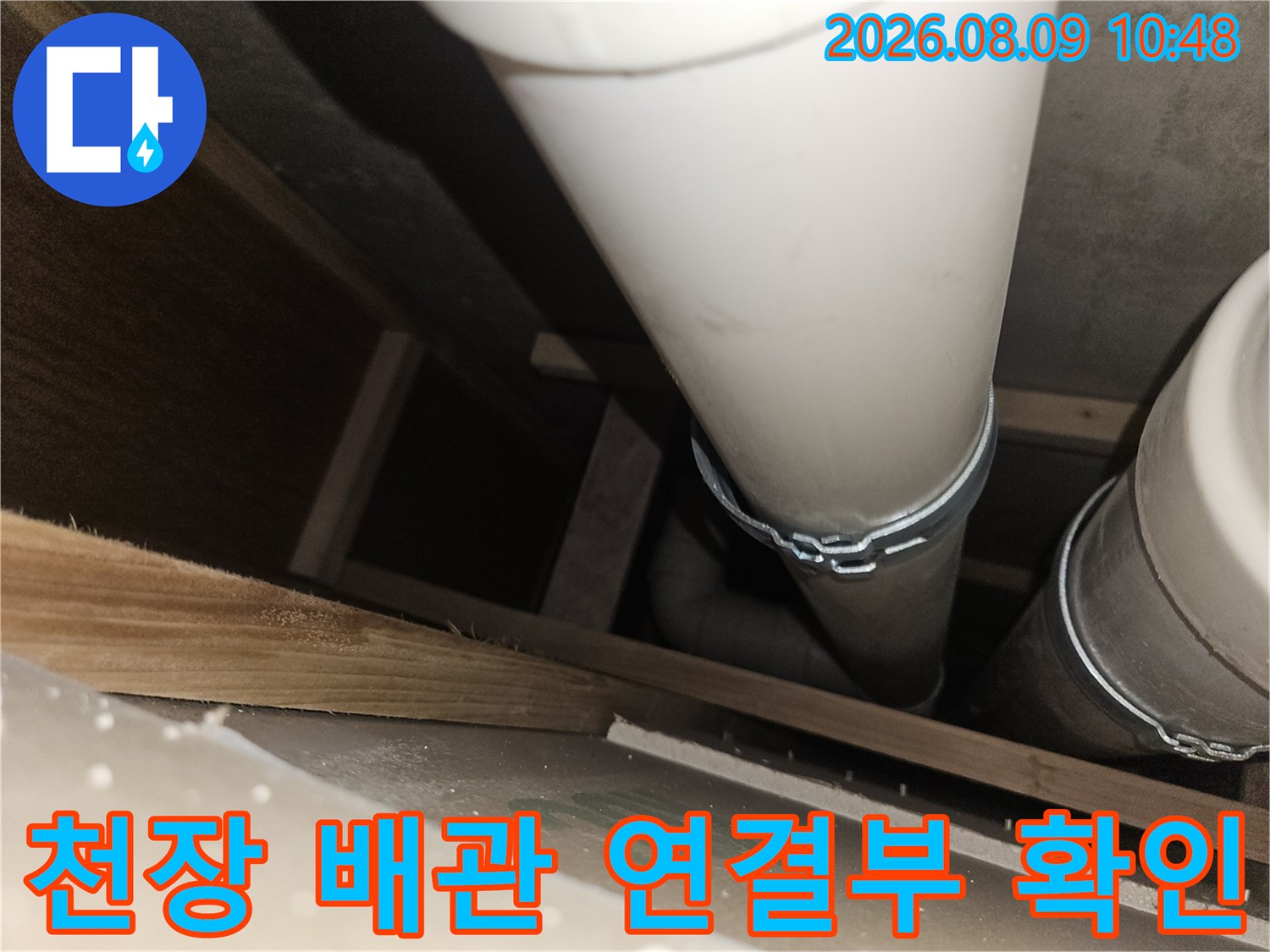 천장 내부의 하얀색 배수 배관과 연결 부위를 점검하는 모습