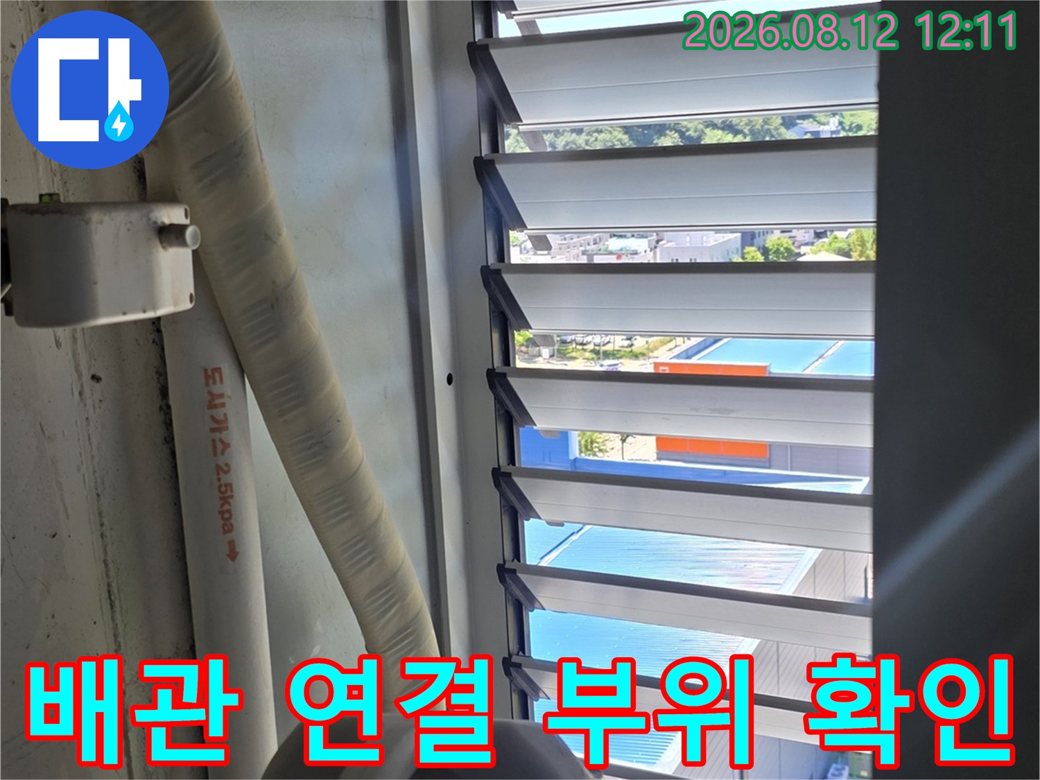 창가 쪽 배관과 흰색 마감재 주변의 습기 상태를 점검하는 장면