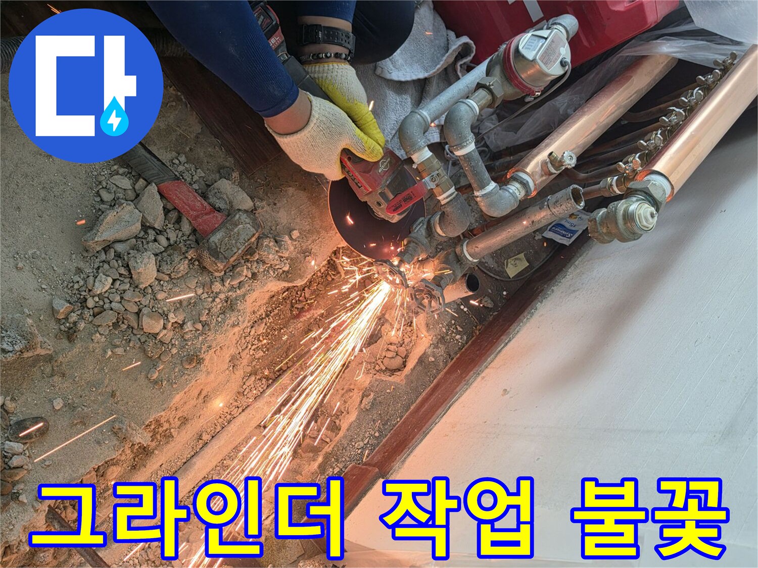 작업자가 그라인더로 노후된 배관 부위를 절단하며 불꽃이 튀고 있습니다.