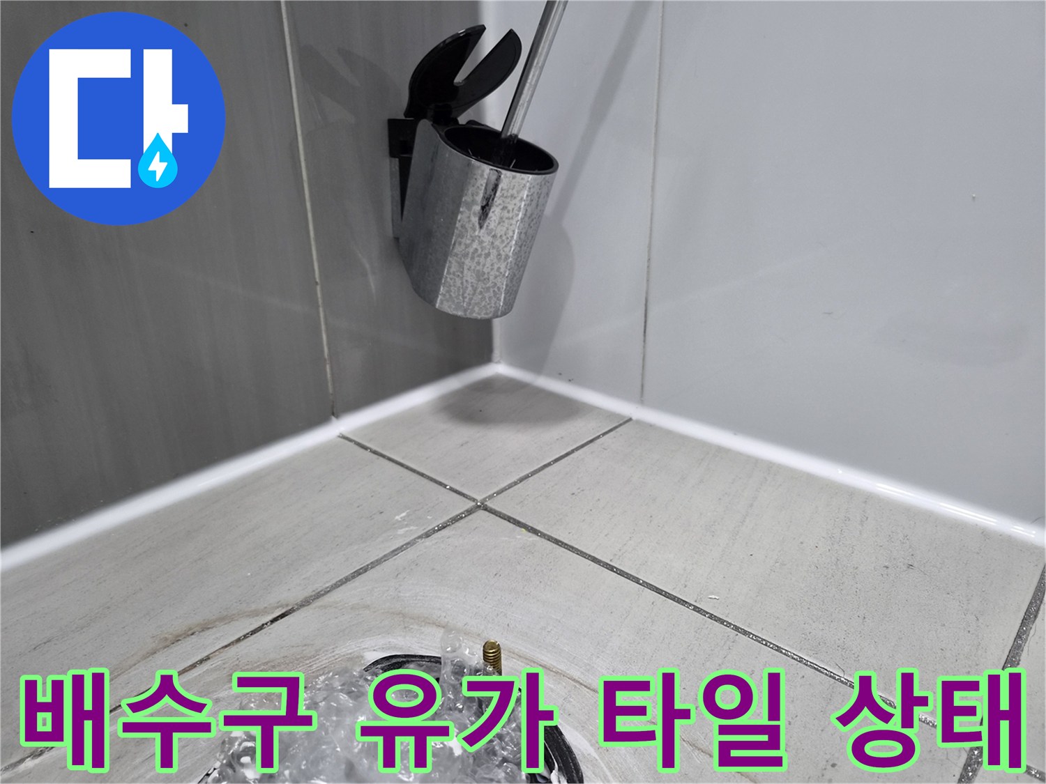배수구 주변 타일의 틈새와 습기 머금은 상태를 보여주는 사진입니다.