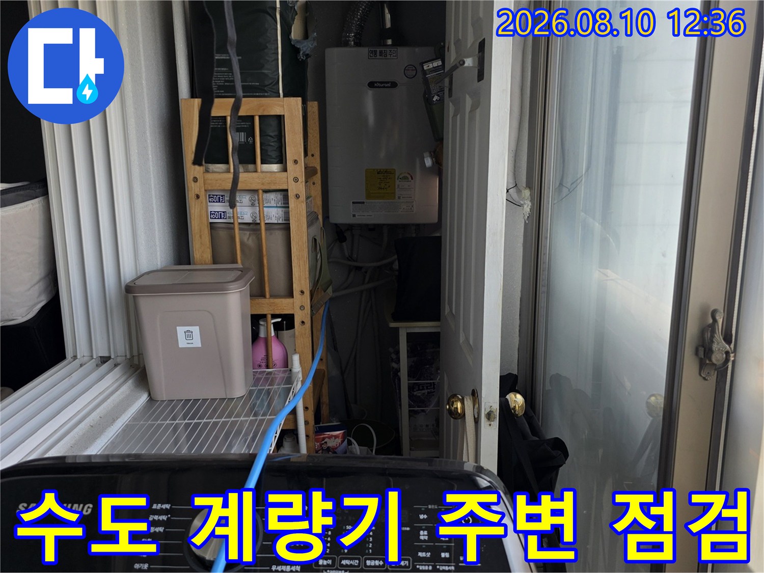 아파트 베란다에 설치된 수도 계량기와 연결 배관의 상세 모습입니다.