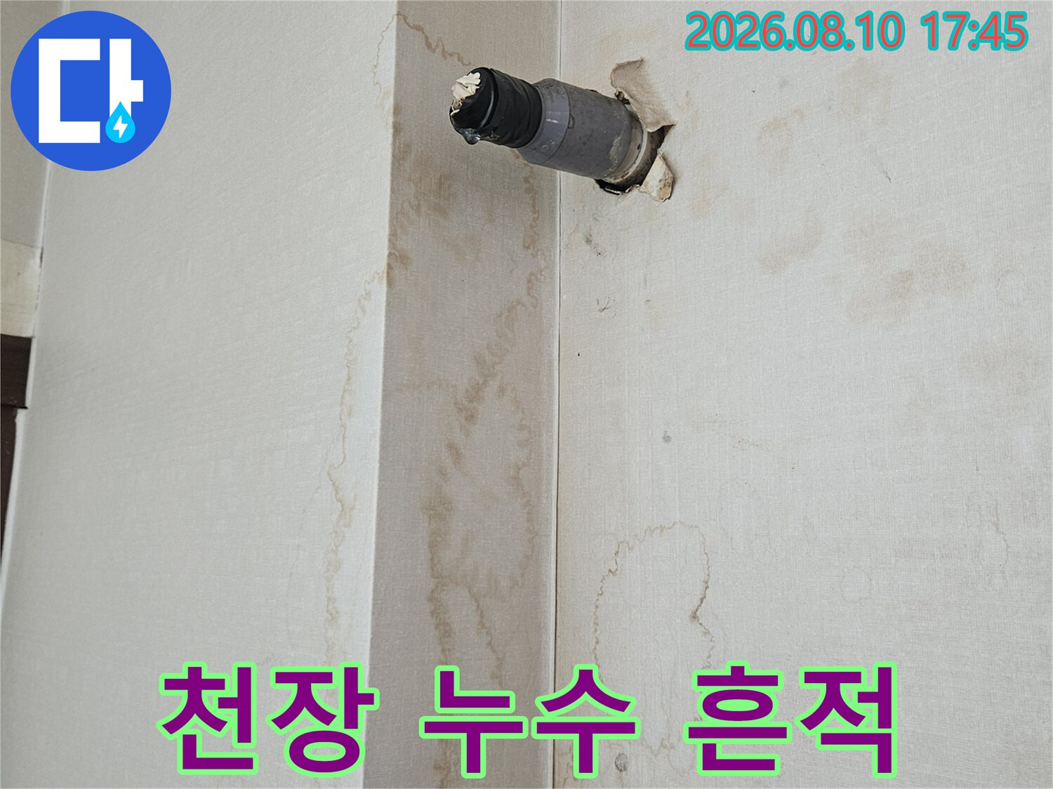 갈색으로 변한 천장 얼룩과 노출된 배관 연결 부위