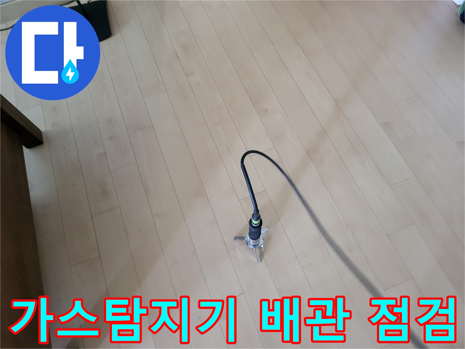 거실 바닥면에서 가스 탐지기를 활용하여 누수 지점을 추적하는 모습
