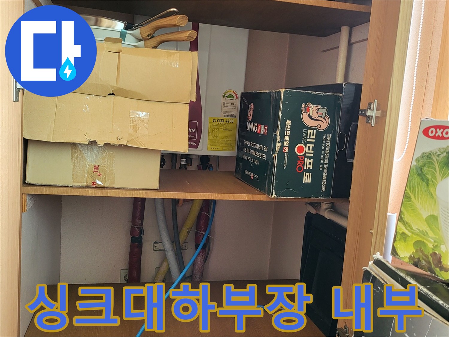 싱크대 하부장 안쪽의 정리된 물품과 배관 주변 모습