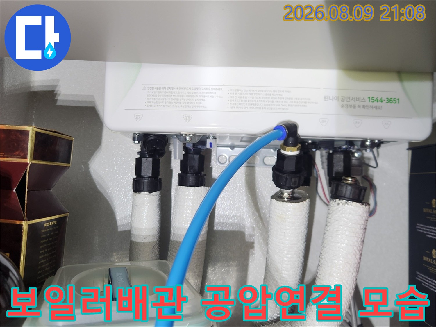 보일러 하부 배관에 파란색 공압 테스트 호스가 연결된 모습