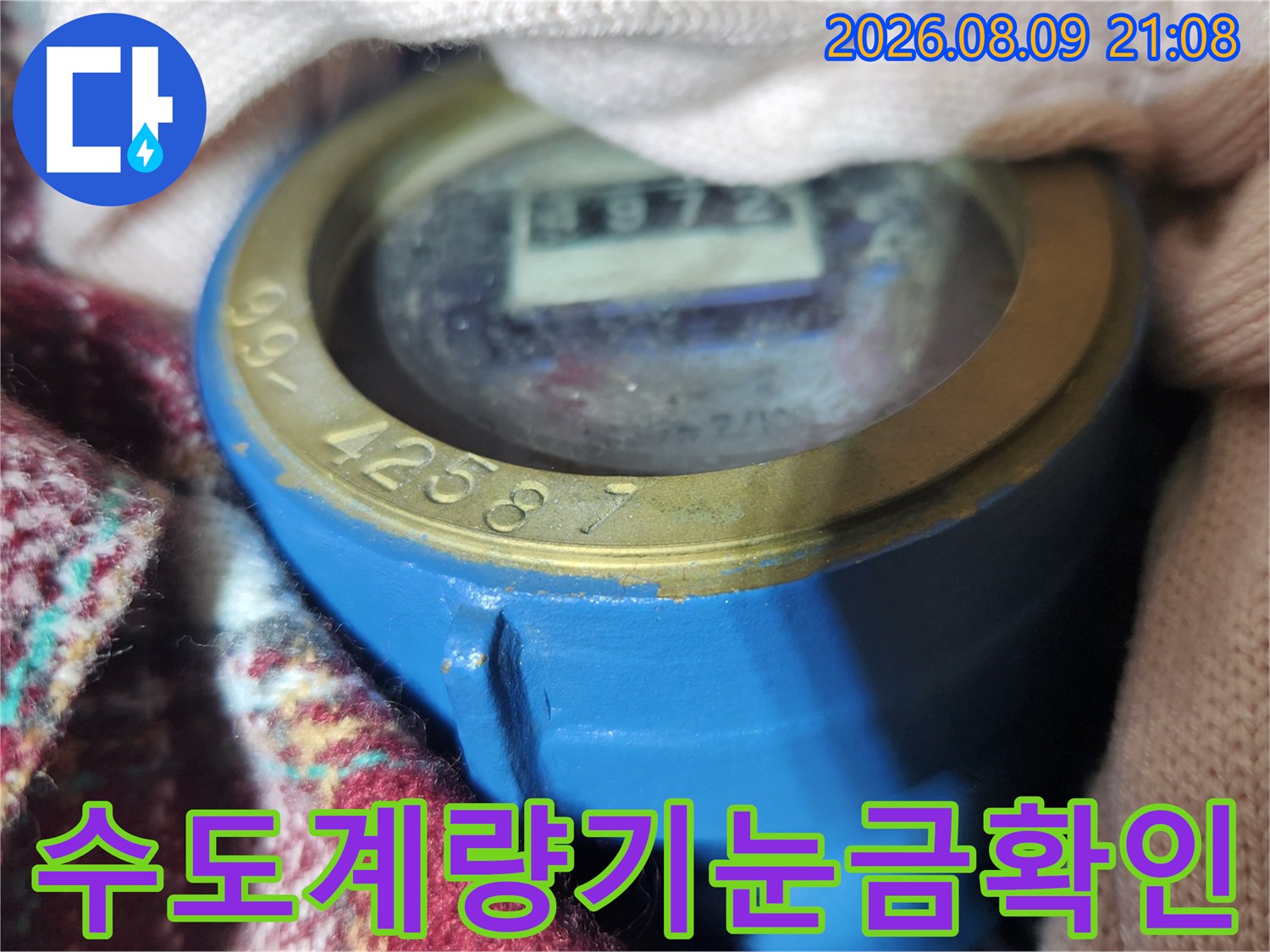 파란색 케이스의 수도 계량기 내부 눈금과 별침이 보이는 클로즈업 사진