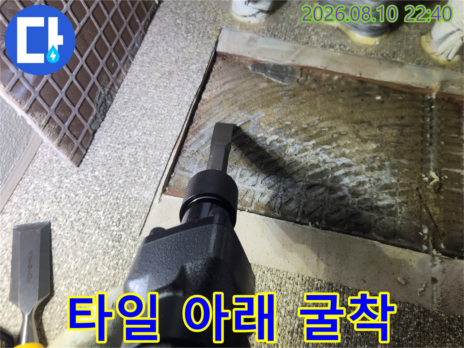 누수 지점을 노출시키기 위해 타일 주변을 파내는 작업 모습입니다