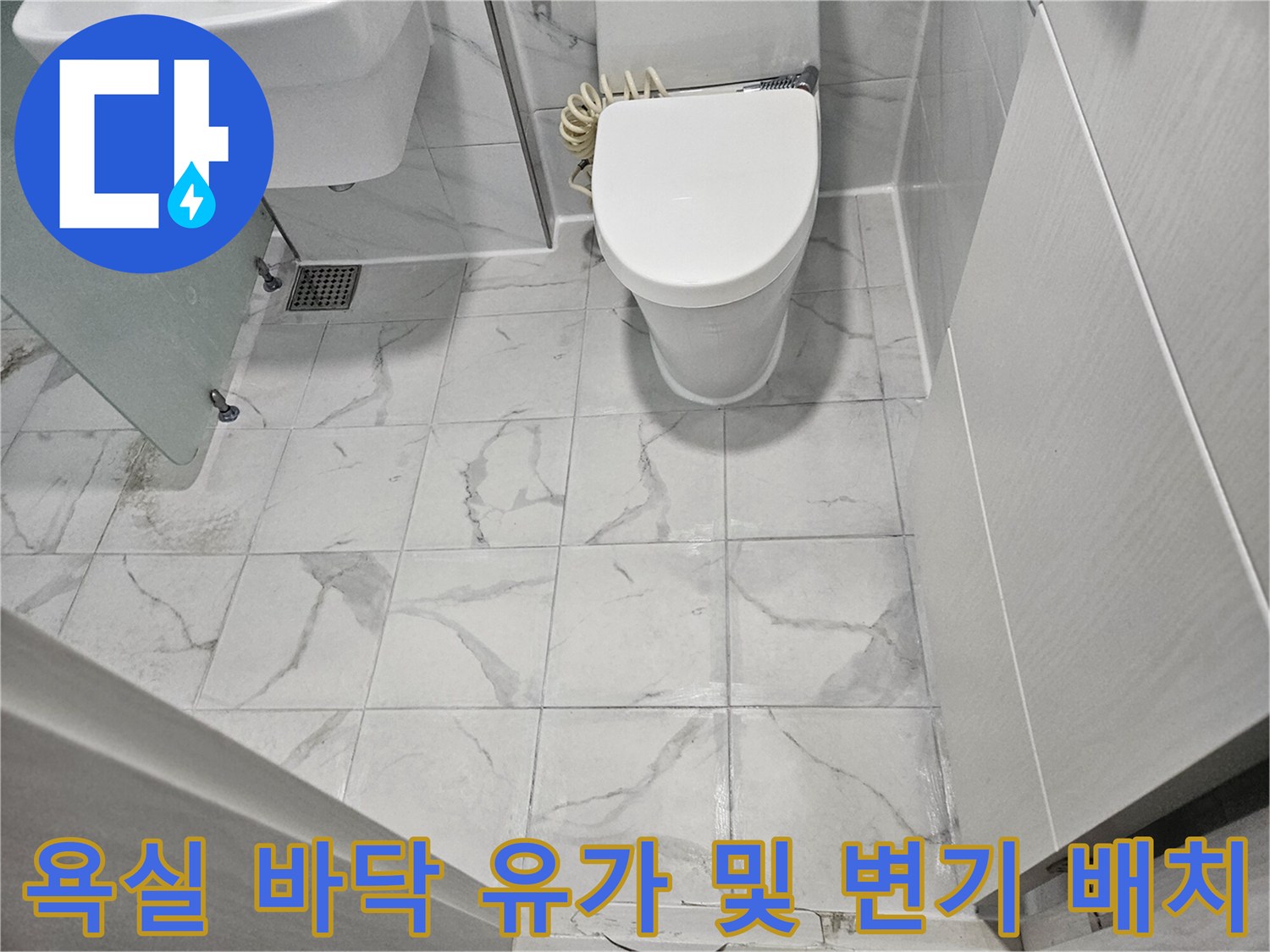 대리석 무늬의 밝은색 욕실 타일-변기와 배수구가 설치된 바닥 모습